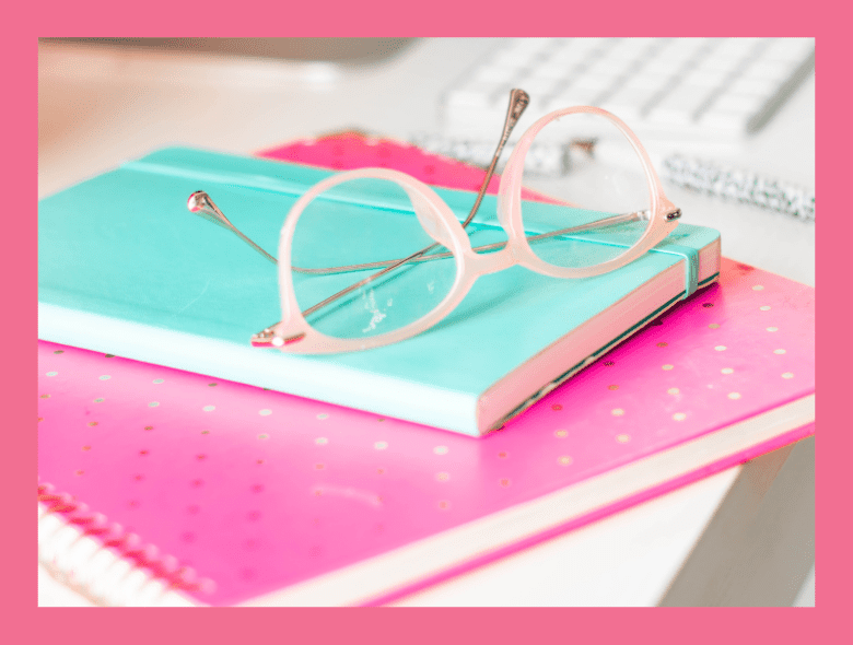 Two planners stacked and a pair of glasses.