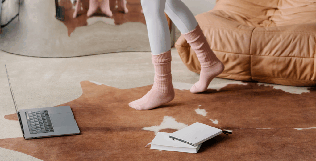 Entrepreneur stepping away from laptop and notebook on the floor illustrating how lack of business systems can stall implementation and the need for structured systems to follow through with ideas.
