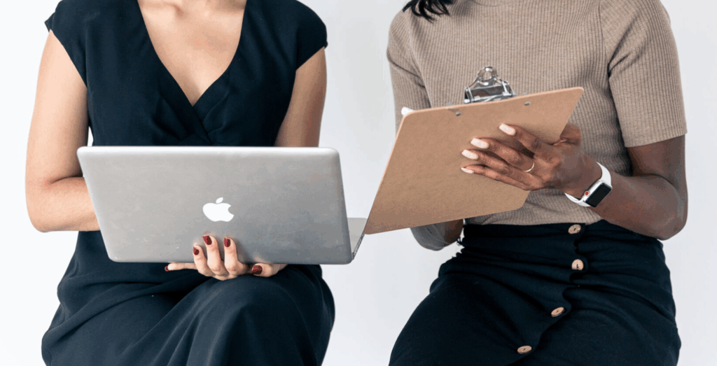 Two entrepreneurs reviewing notes and laptop together, representing business support and collaborative systems that help turn idea to execution.