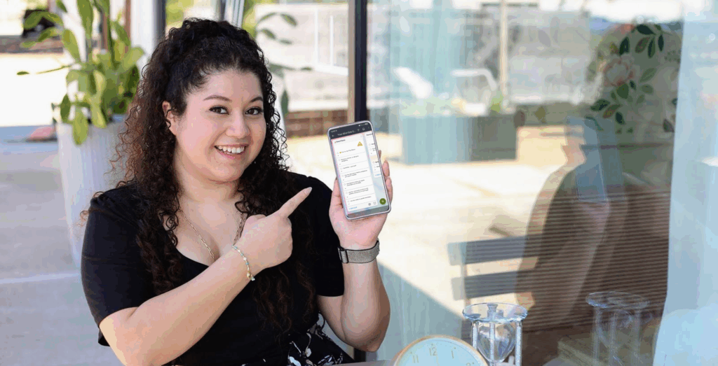 Entrepreneur holding phone with Trello board visible, demonstrating Trello boards for business and how Trello project management organizes daily operations.