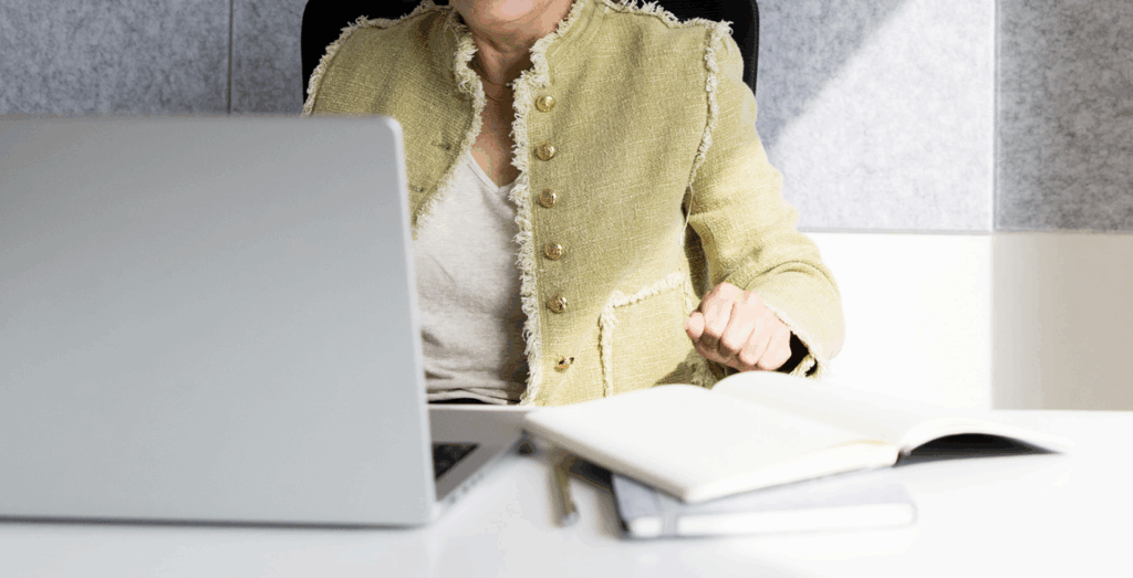 Entrepreneur working at laptop with notebook, representing how Trello workflow and simple project management tools help organize business tasks.
