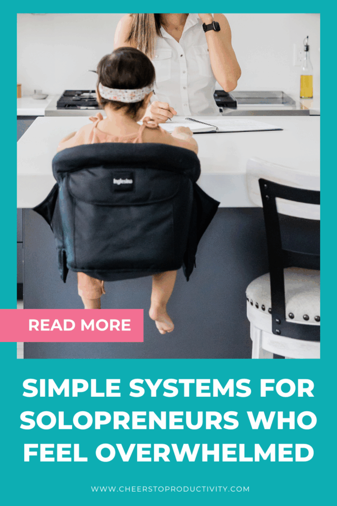 Pinterest graphic showing a solopreneur working at the kitchen counter with a child nearby, representing simple business and life systems, sustainable systems for solopreneurs, and systems for real life that reduce overwhelm.