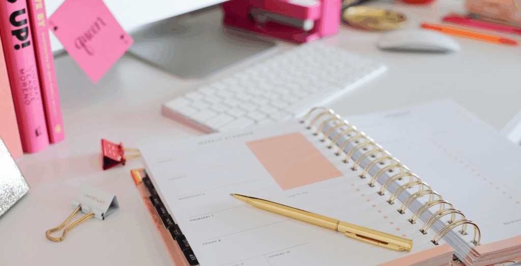 Open planner and organized workspace with office supplies, illustrating simple systems and small business systems for entrepreneurs building systems to improve productivity, planning, and everyday business systems.