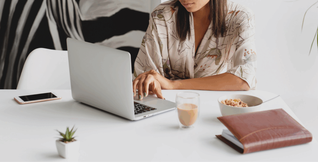 Solopreneur working on a laptop at a clean desk with coffee and planner, representing simple systems for an overwhelmed solopreneur and managing the feeling overwhelmed that comes with running a business.